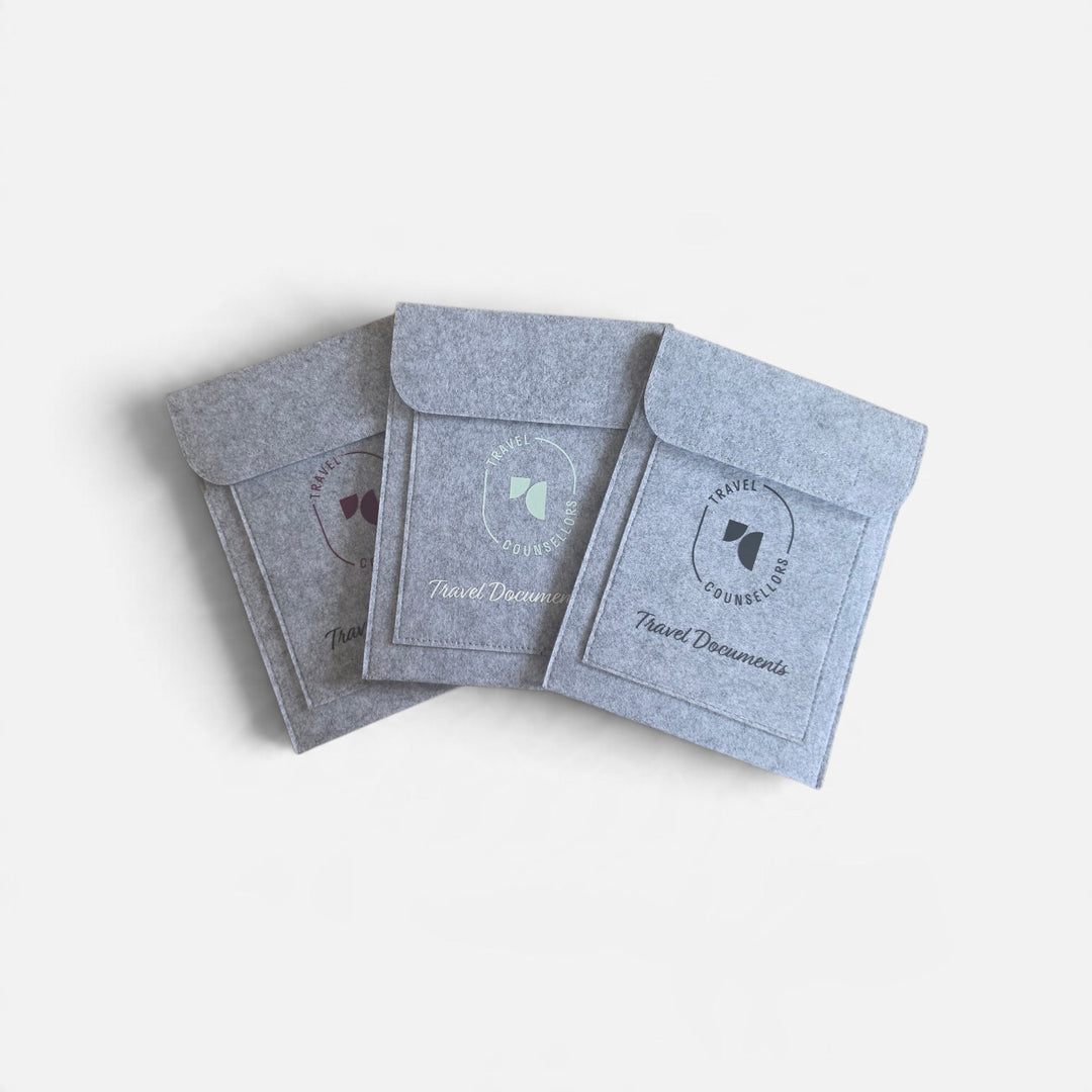 Well Travelled Wallets grey felt document organiser wallets with Travel Counsellors branding on a white background